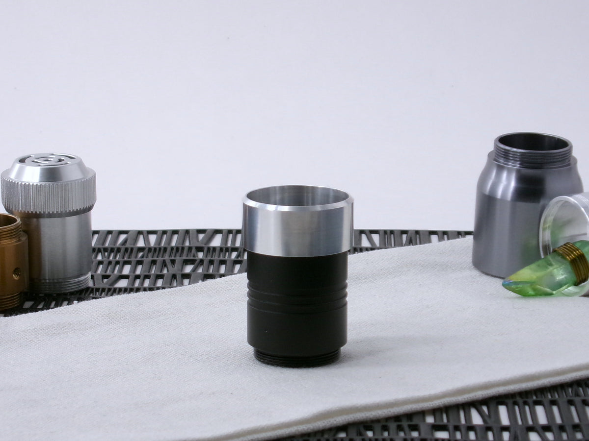 A VHC-compatible, lightsaber Accent Cap, positioned for installation, shim side down on a VHC-component.