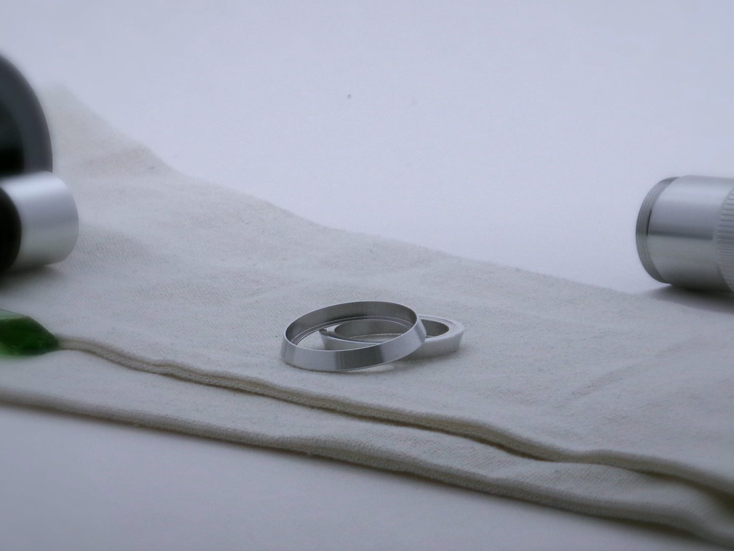 Pair of bevelled aluminum accent rings for VHC lightsabers, one askew upon the other, showing shimsert.