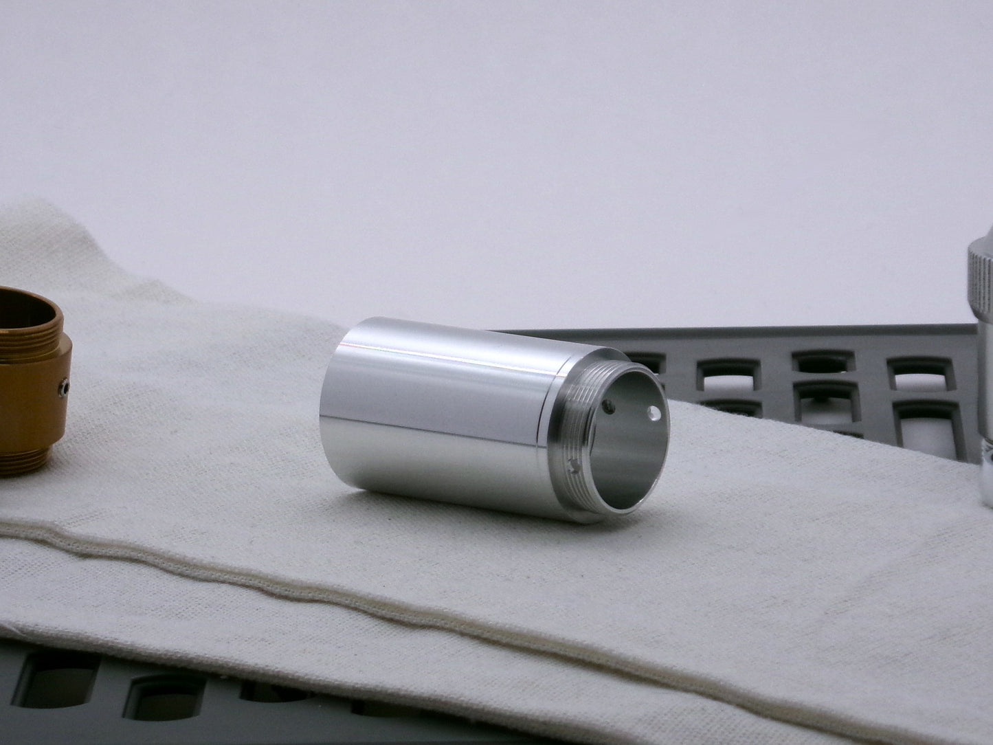 Single, aluminum male/male threaded adapter for VHC lightsabers installed in a Type_3 Body Component; 33mm diameter. Three-quarter view.