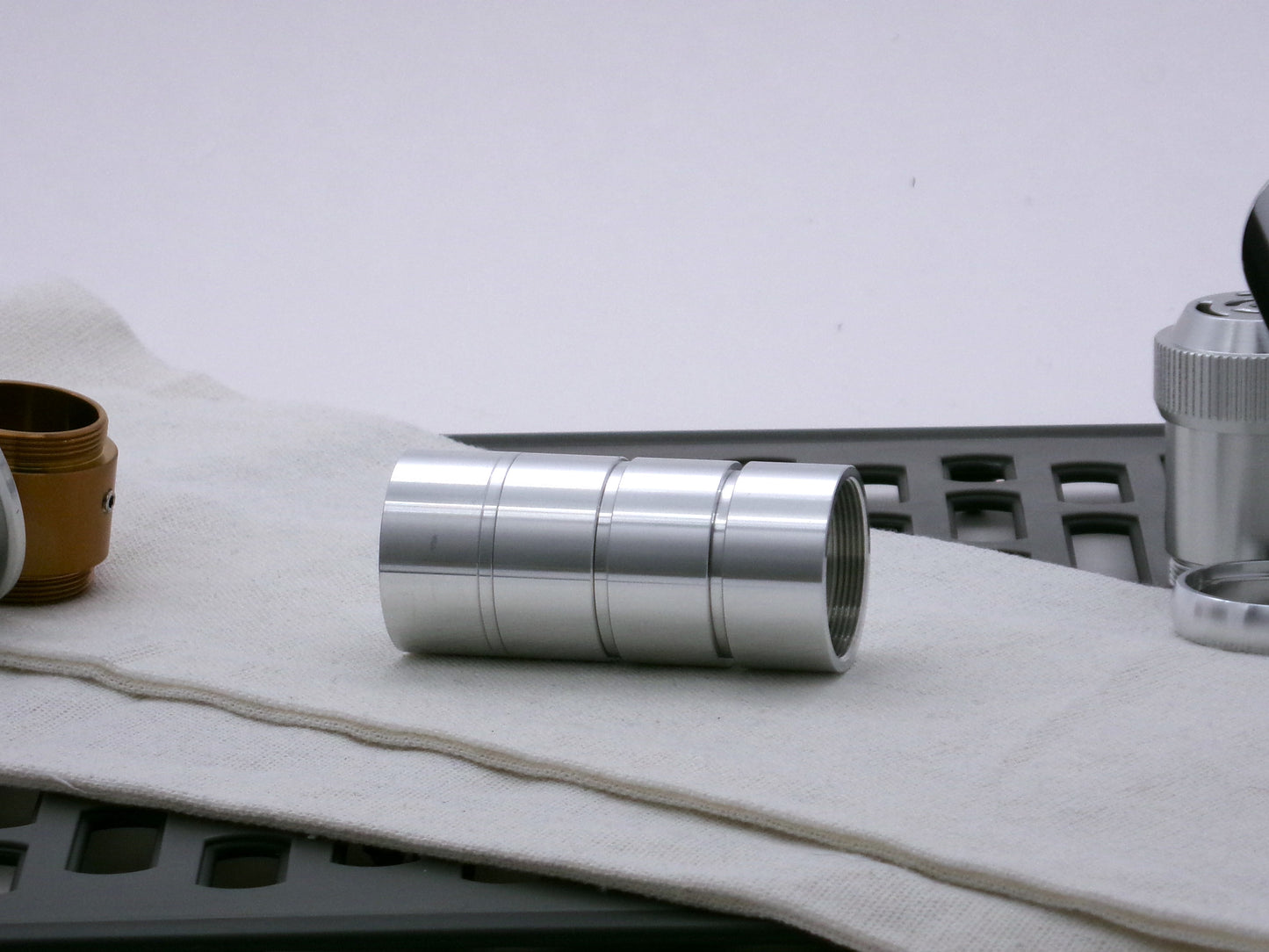 A trio of aluminum, Male/Male threaded adapters installed into four VHC lightsaber components demonstrating the variance in adapter diameter.