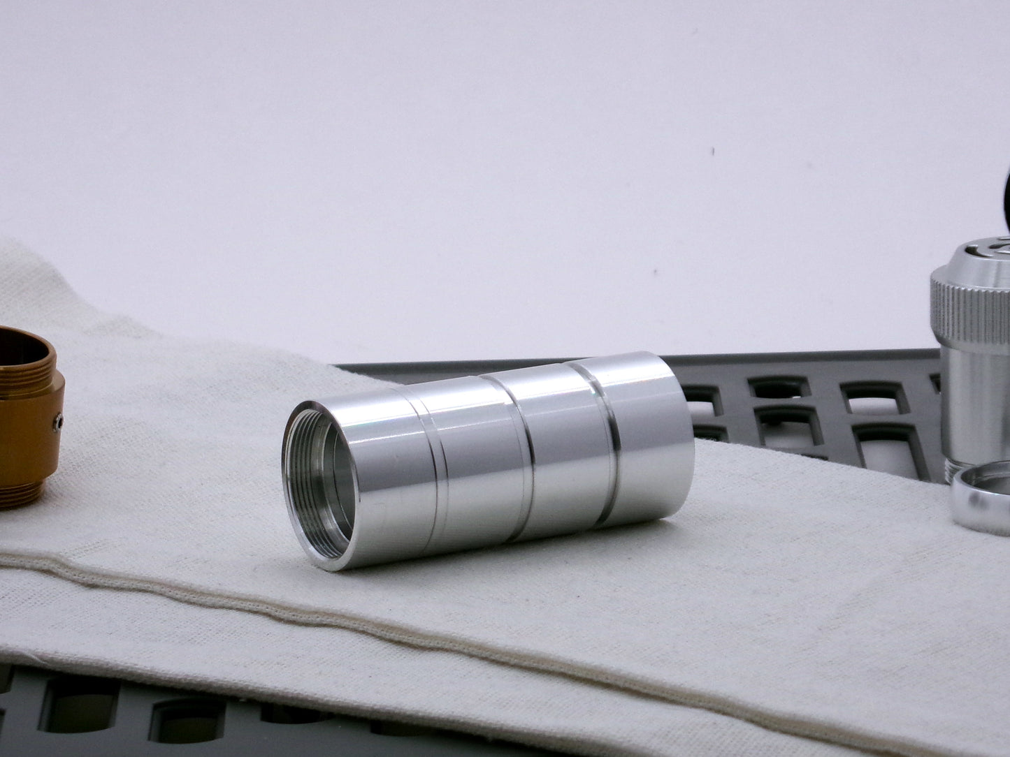 A trio of aluminum male/male threaded adapters installed into four VHC lightsaber components, demonstrating the variance in adapter diameter.