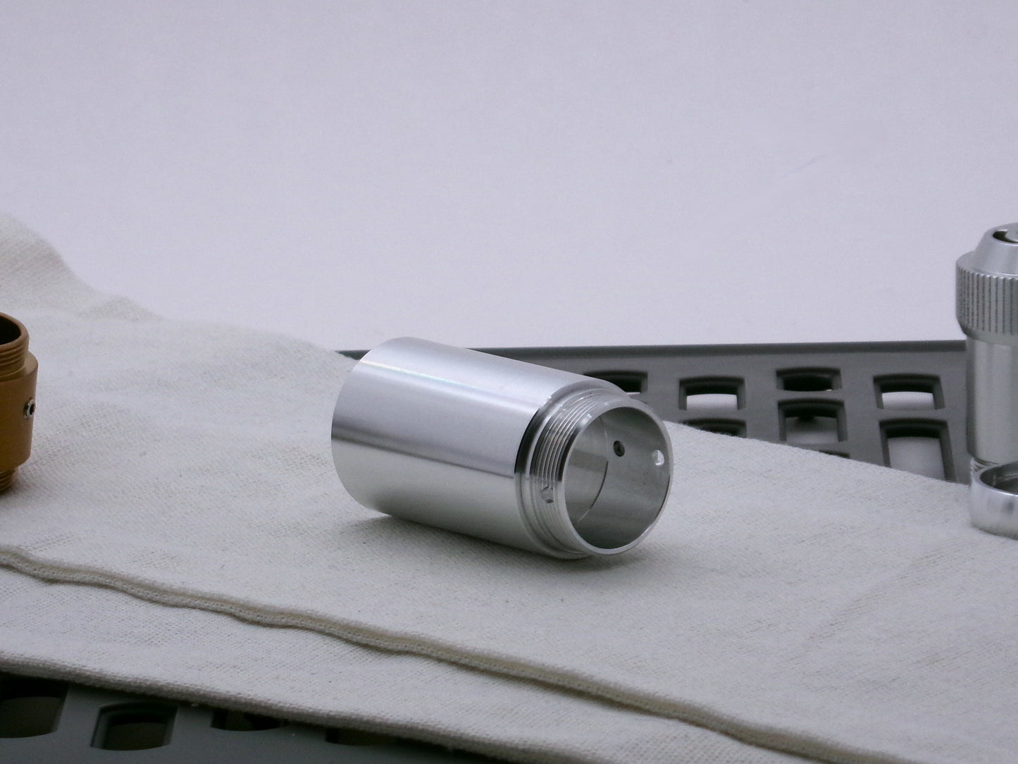 Single, aluminum male/male threaded adapter for VHC lightsabers installed in a Type_2 Body Component; 30mm diameter. Three-quarter view.