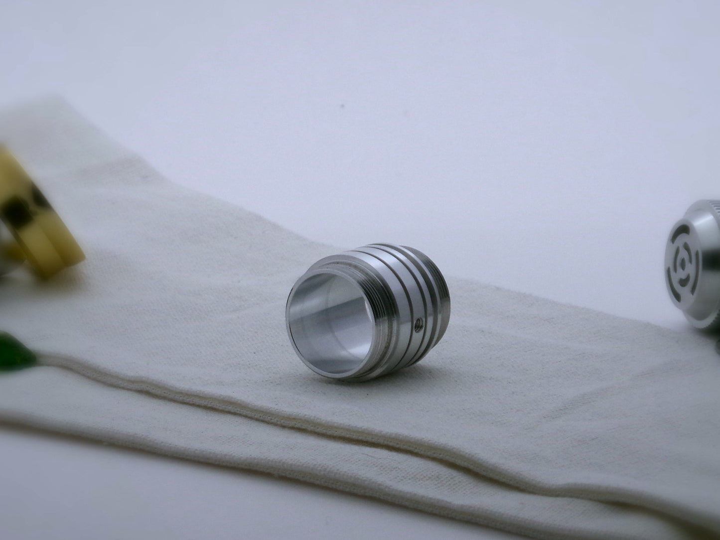 An aluminum, Male/Male threaded, adapter for VHC lightsabers adorned with ribs and grooves in the Clan Lightsaber style; Three-quarter view.