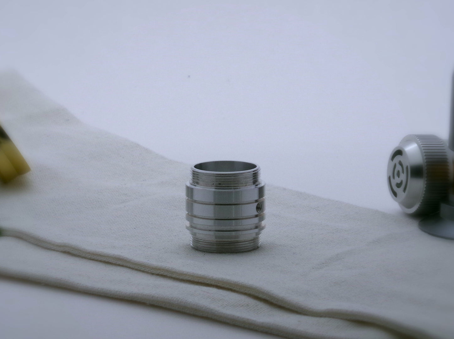 An aluminum, Male/Male threaded, adapter for VHC lightsabers adorned with ribs and grooves in the Clan Lightsaber style.