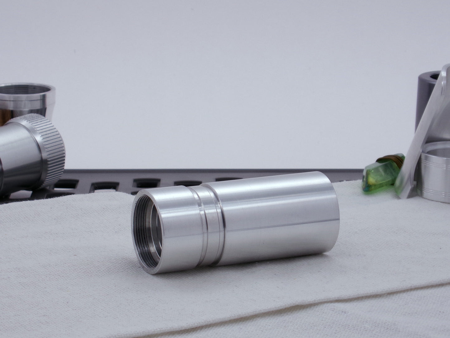 Ki Adi Mundi styled, stepped male adapter for VHC lightsabers, installed between two body components, resting on cloth, three-quarter view angled left.