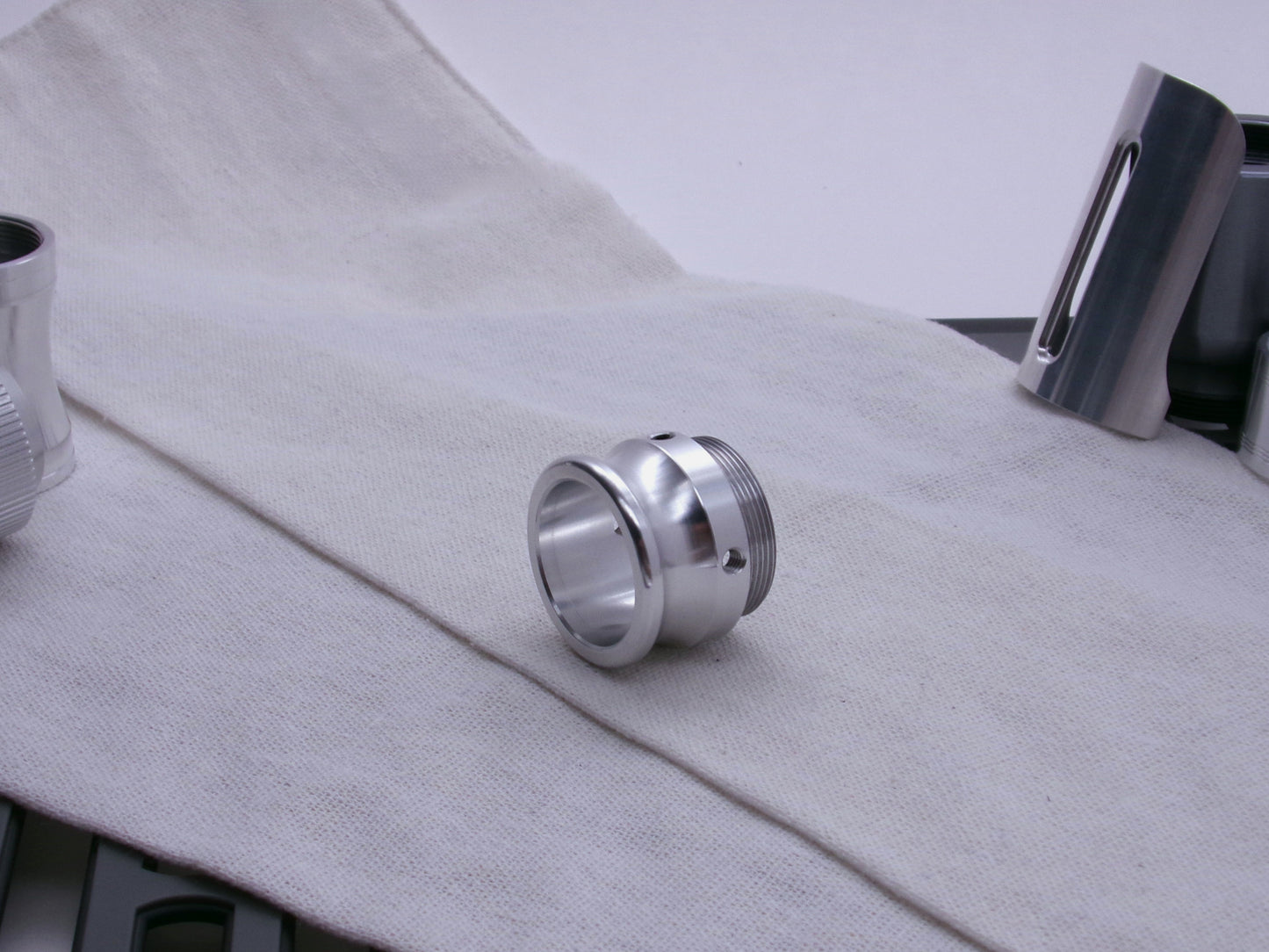 An emitter tip, 3/4 view resting on a coarse cloth.