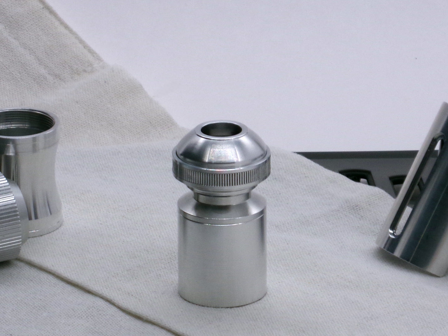 A basic, aluminum female-threaded pommel installed on Adapter MM Hybrid Type 1 with Accent Ring Type 1.1 all installed on a Body Segment Type 2, standing vertical.