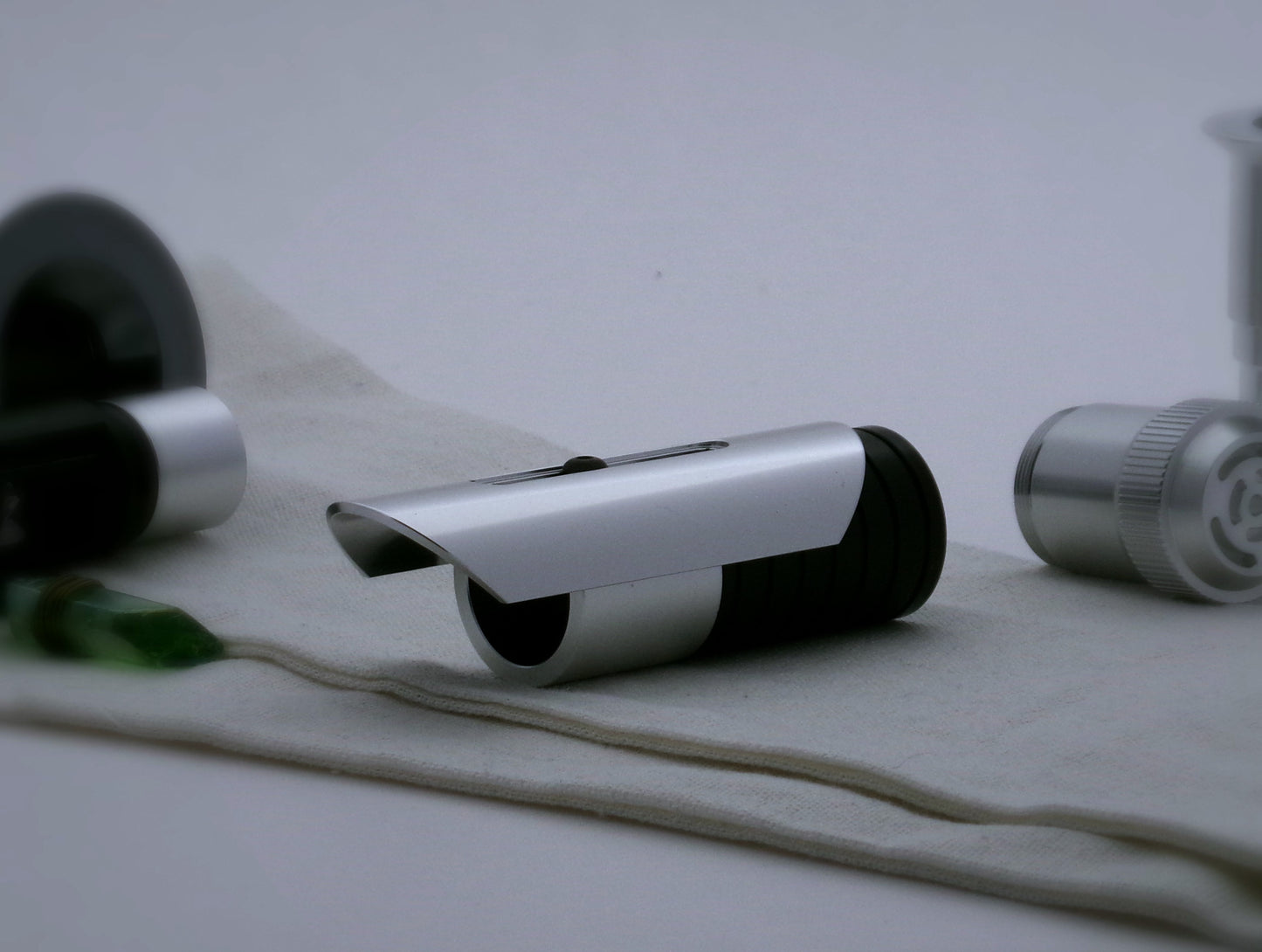 Aluminum half shroud for VHC lightsabers with angled ends mounted by a universal slot to an emitter mock-up; three quarter view.