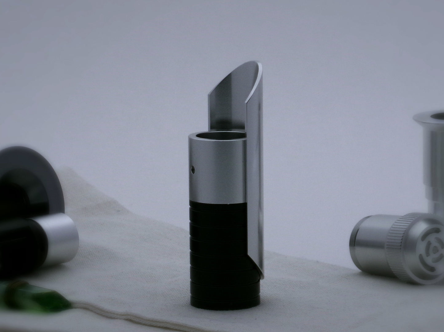Aluminum half shroud for VHC lightsabers with angled ends mounted by universal slot to an emitter mock-up; vertically oriented.