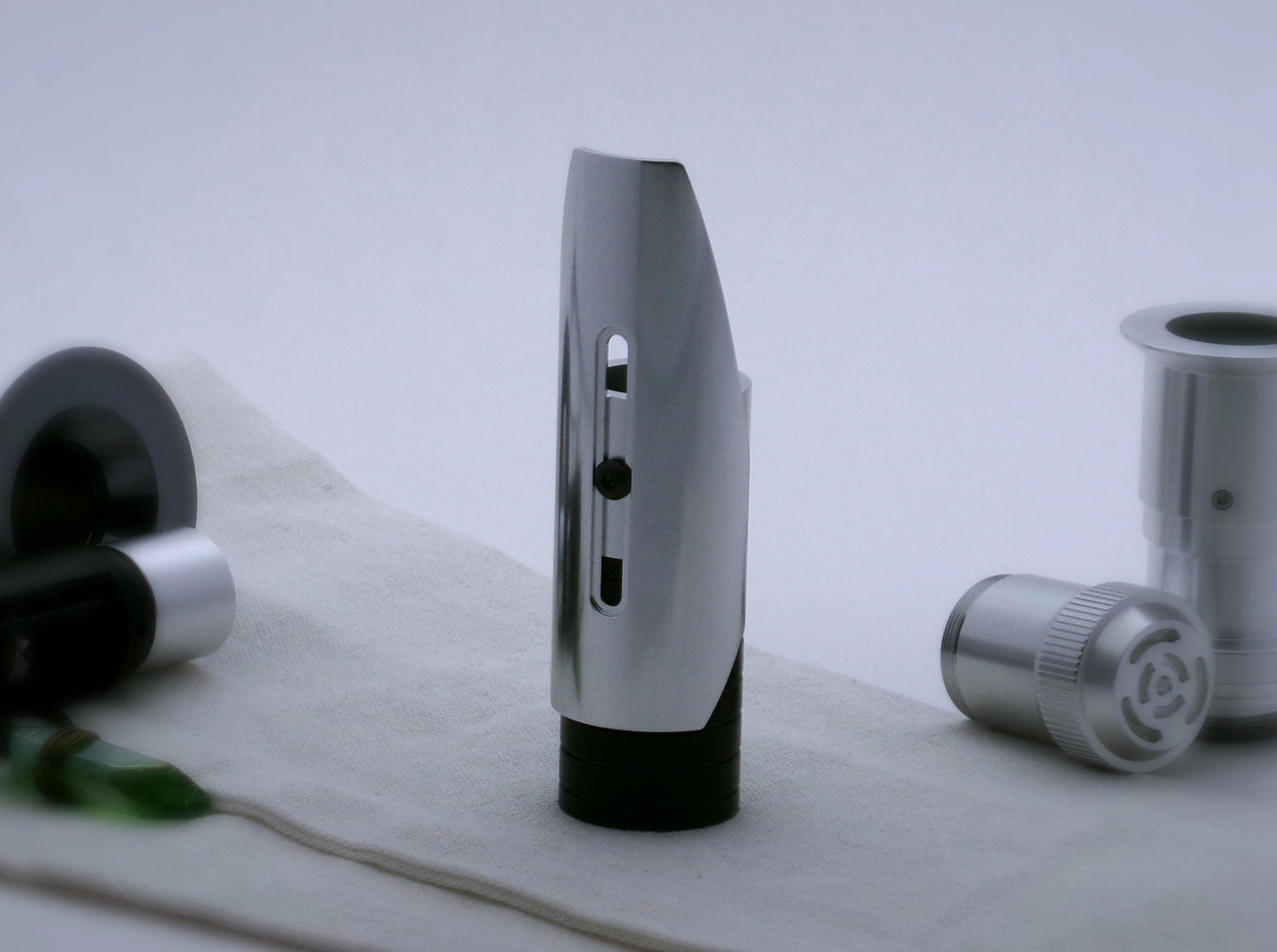 Aluminum, shield shaped half shroud for VHC lightsabers mounted by universal slot to an emitter mock-up; vertically oriented posterior view.