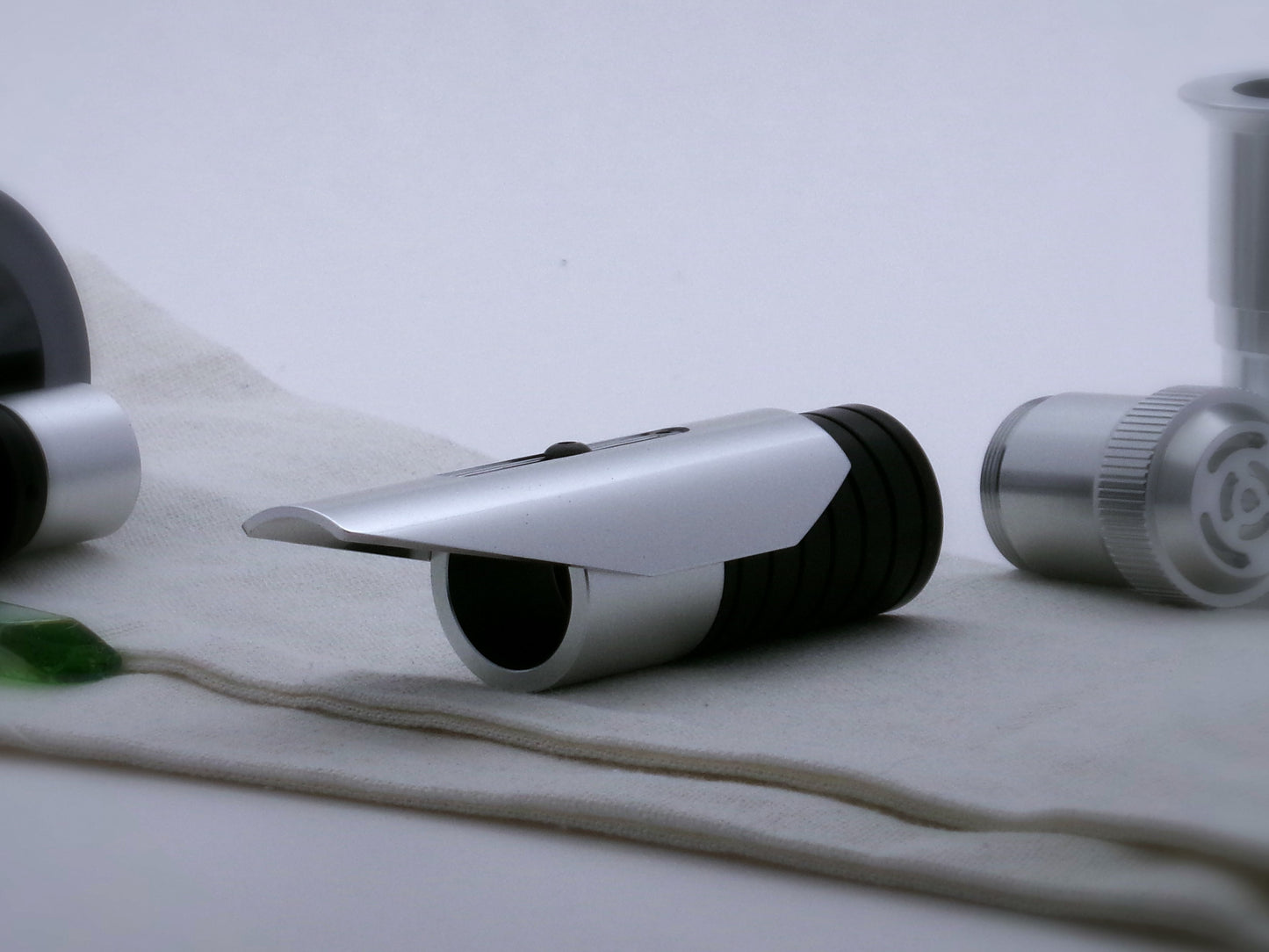 Aluminum, shield shaped, half shroud for VHC lightsabers mounted by universal slot to an emitter mock-up; three-quarter view.