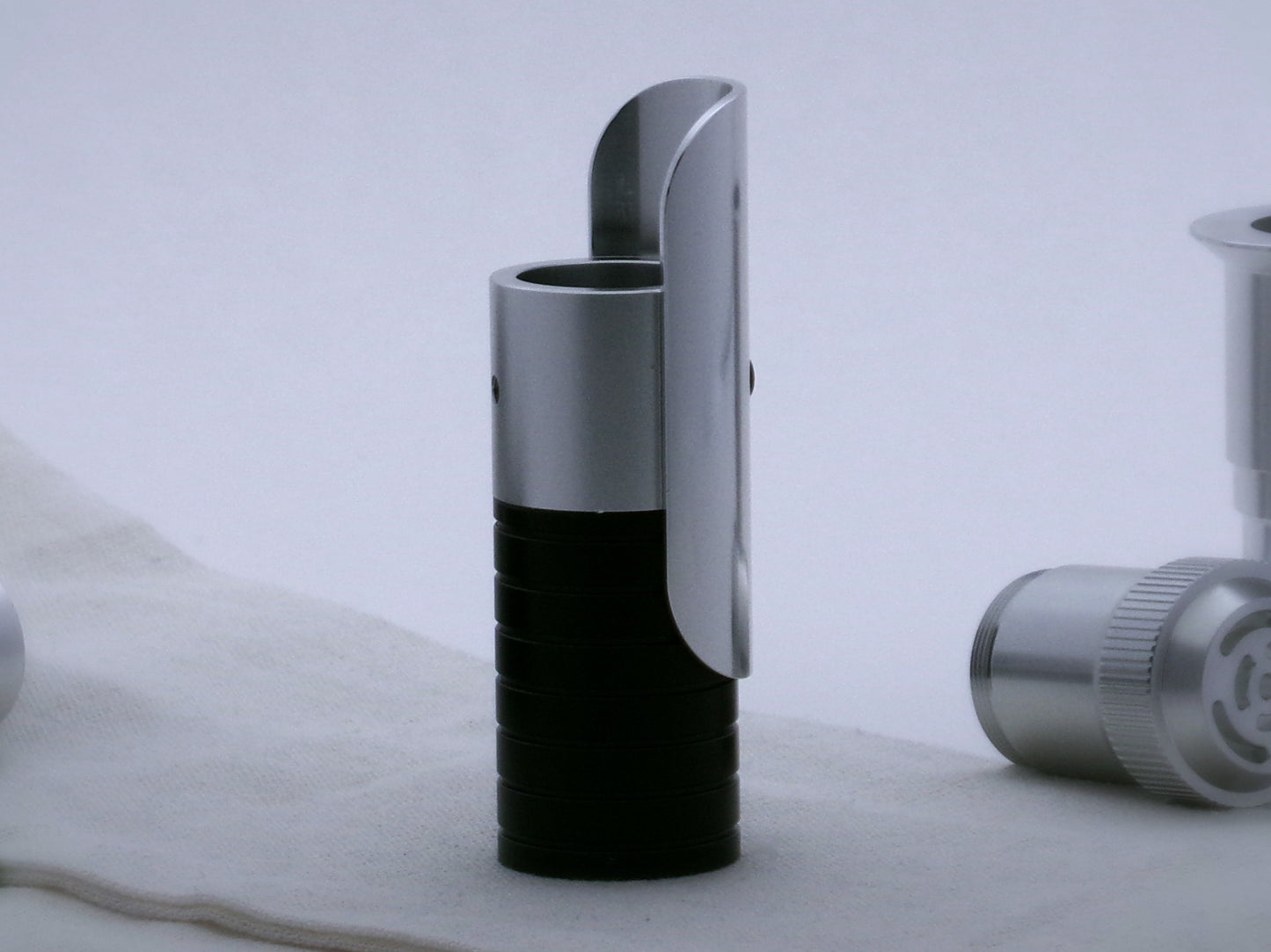 Aluminum half shroud for VHC lightsabers with radiused corners mounted by universal slot to an emitter mock-up; vertically oriented