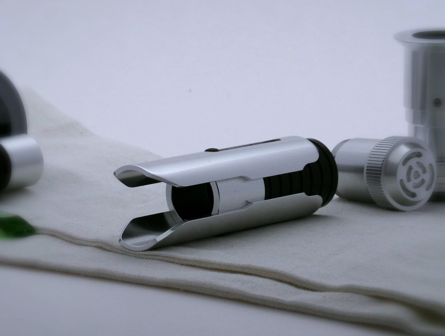 Pair of aluminum half shroud for VHC lightsabers of Kestis design mounted by universal slot to an emitter mock-up; three quarter view.