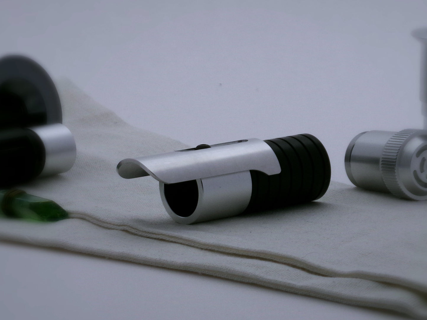 Single, long aluminum half shroud for VHC lightsabers of Sabine Wren design mounted by universal slot to an emitter mock-up; three quarter view.
