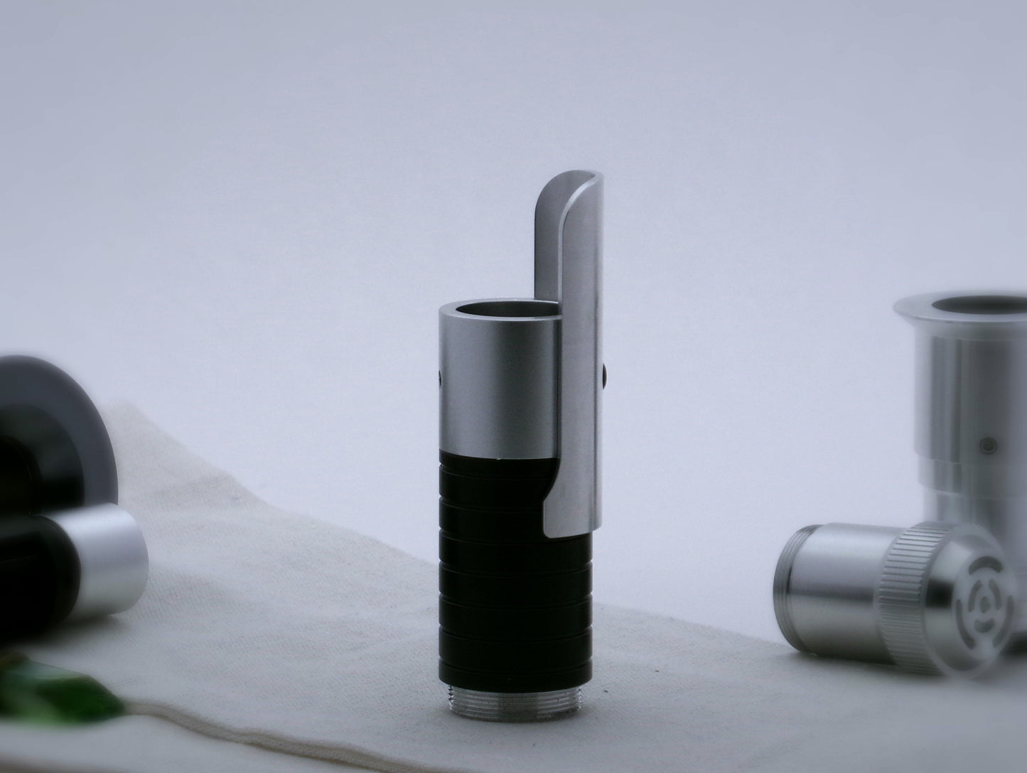 Single, long aluminum half shroud for VHC lightsabers of Sabine Wren design mounted by universal slot to an emitter mock-up; vertical orientation, lateral view.
