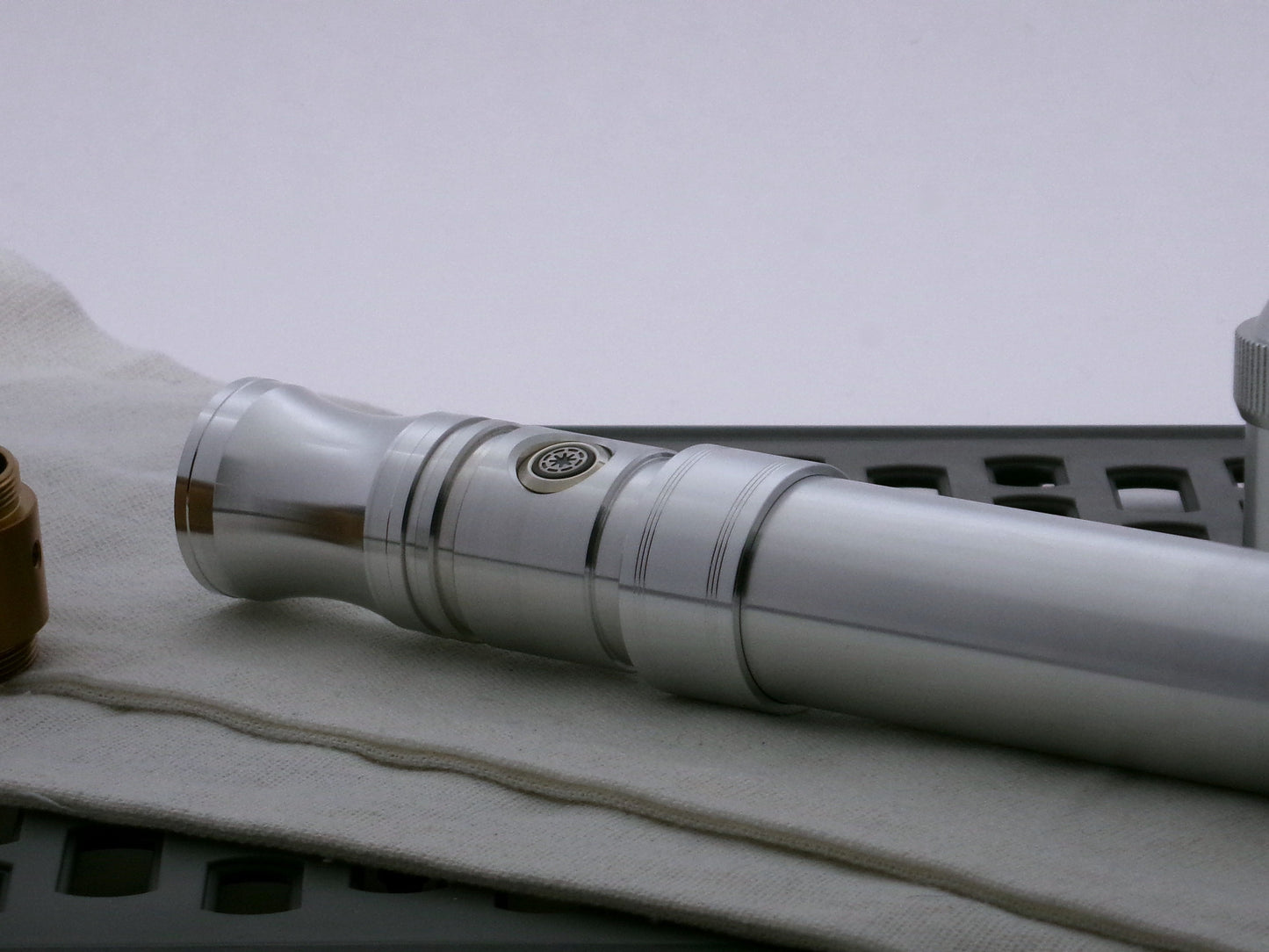 Single aluminum accent band sporting two-trios of debossed embellishments installed on a VHC lightsaber hilt.