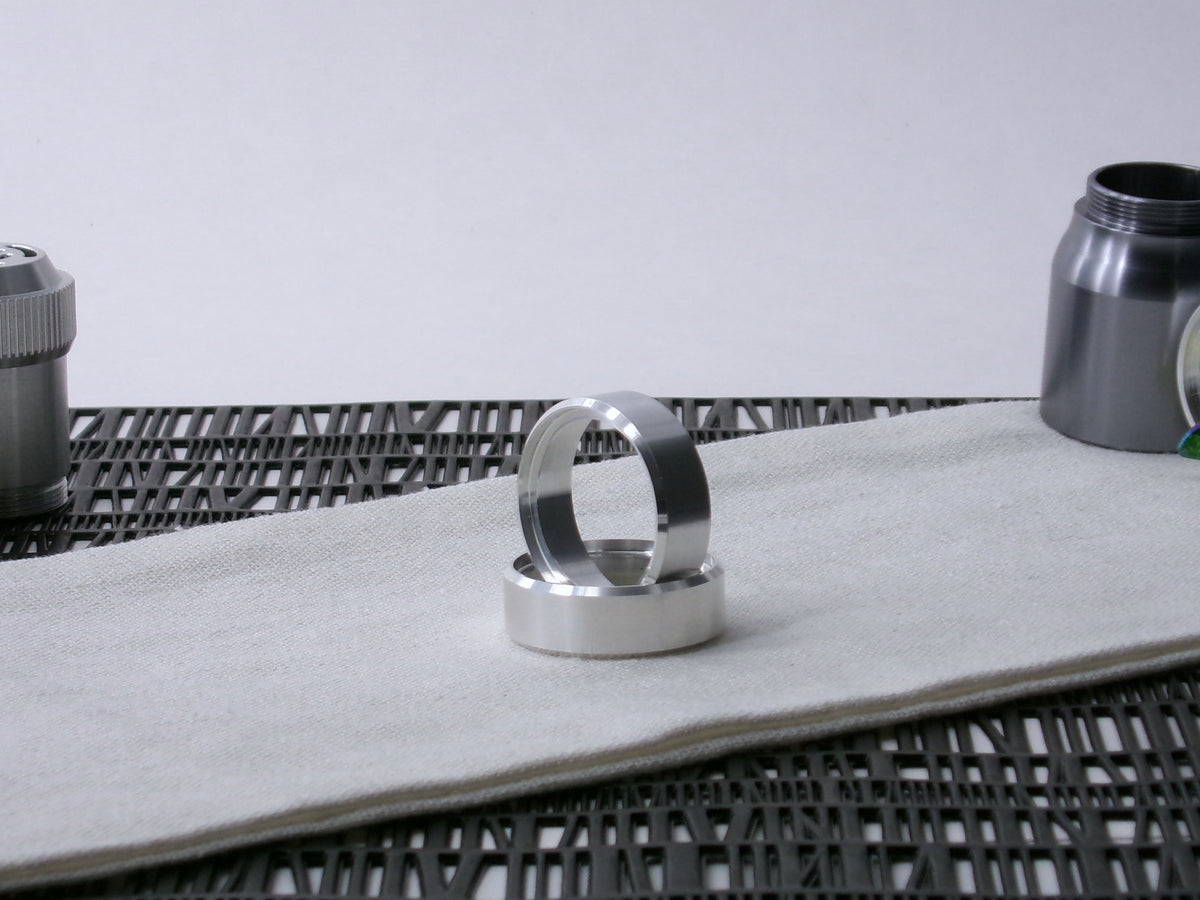 A pair of VHC compatible lightsaber accent bands, one supporting the other on cloth.