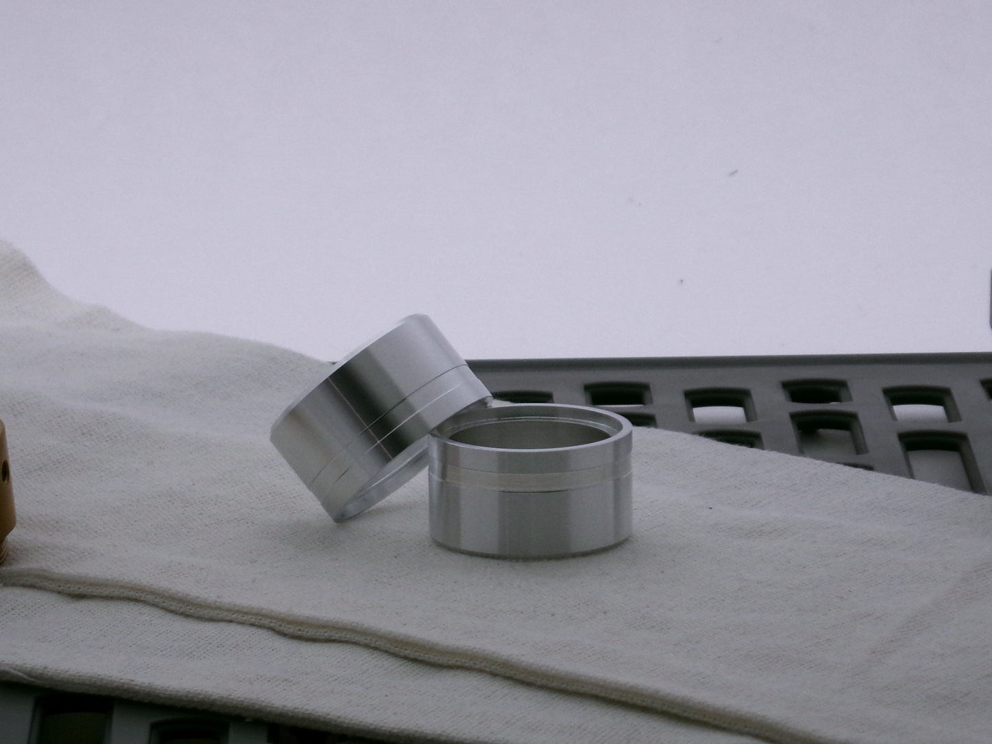 Pair of aluminum lightsaber accent caps for VHC lightsabers, one askew upon the other, showing depth of bevel and debossed embellishments.