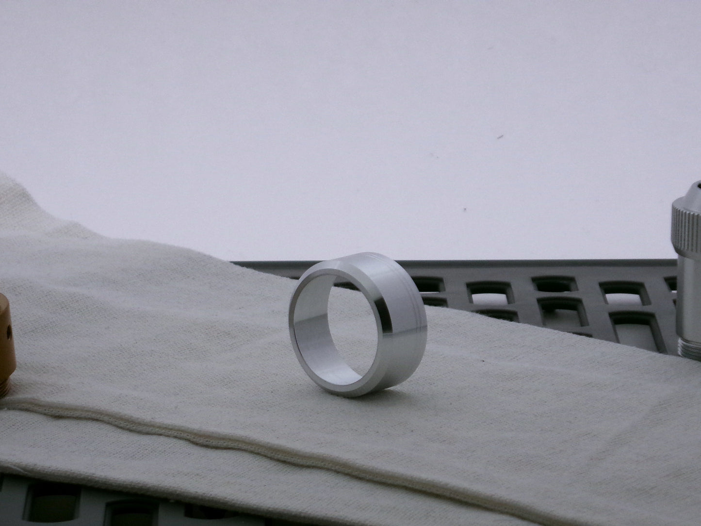Single aluminum accent cap for use on VHC lightsabers, three-quarter view showing detail of beveled face.
