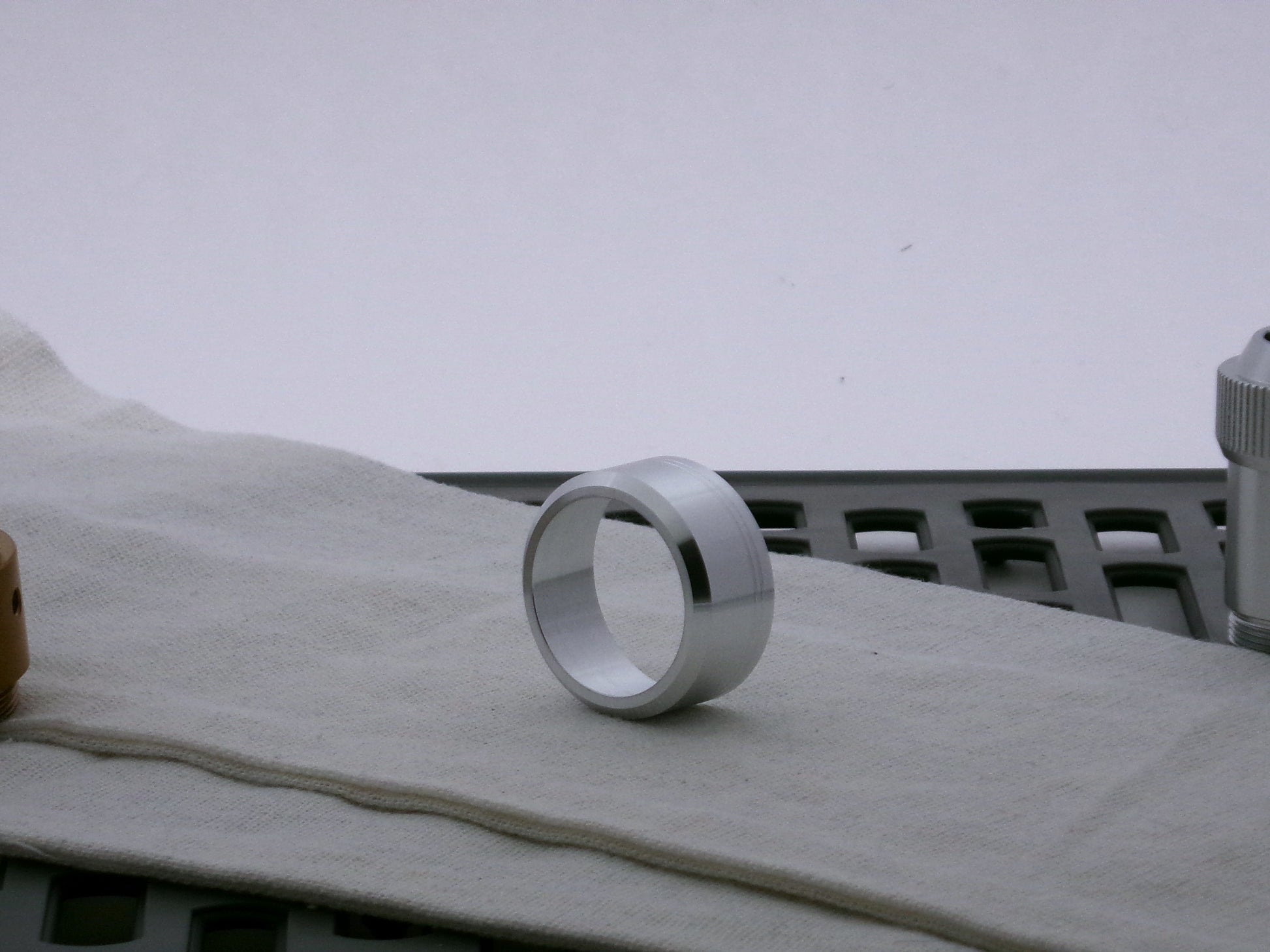 Single aluminum accent cap for use on VHC lightsabers, three-quarter view showing detail of beveled face.