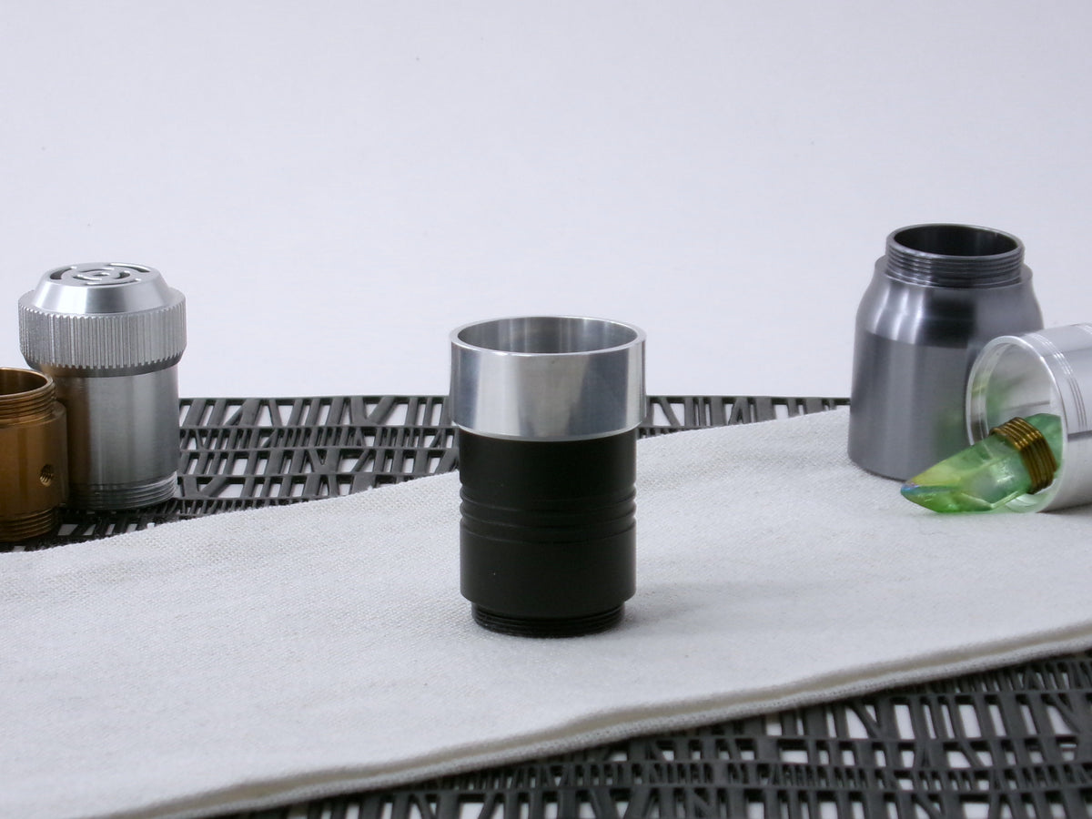 A VHC-compatible, lightsaber Accent Cap, positioned for installation, shim side down on a VHC-component.