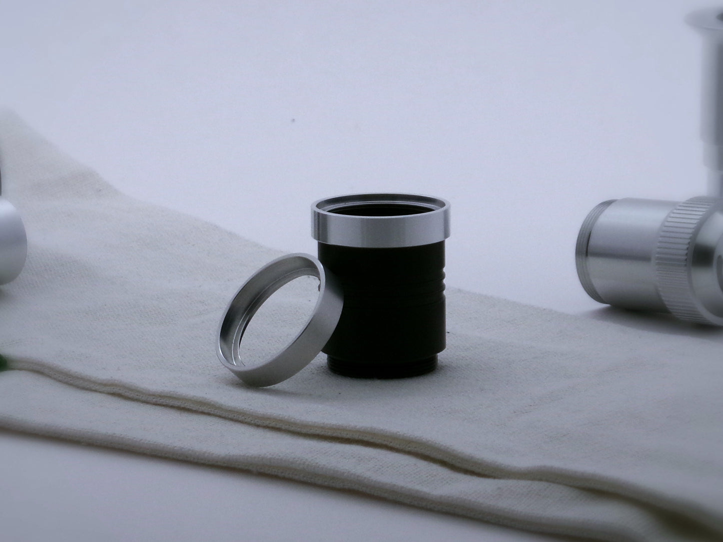 A pair of aluminum accent rings for VHC lightsabers, the first installed on a black grip extension, the second leaning against it.