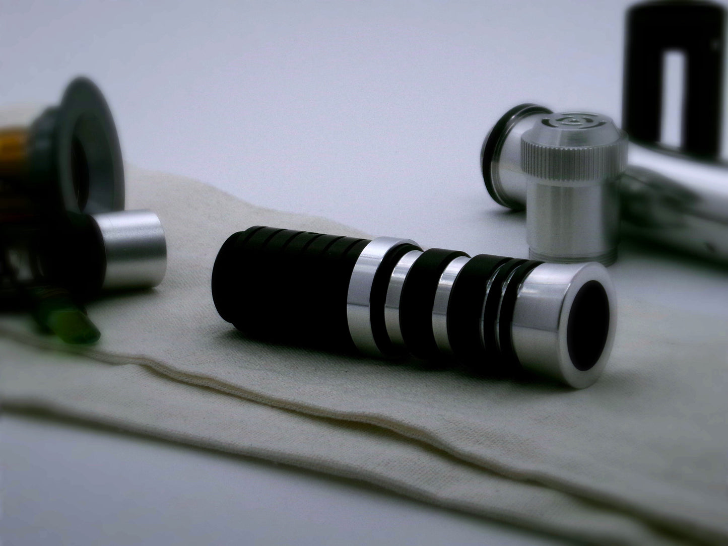 A single, simple aluminum accent ring installed between a mixed finish emitter and black extension of a VHC lightsaber.
