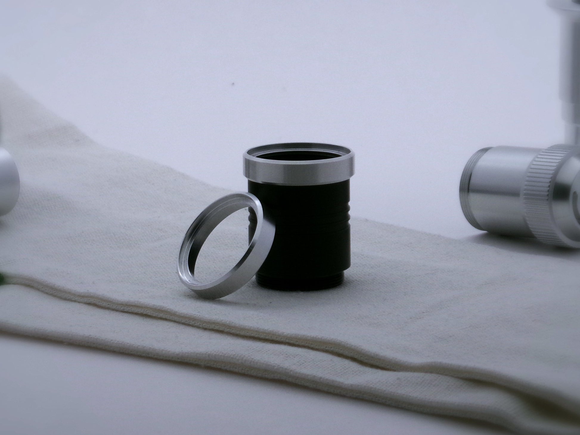 A pair of aluminum accent rings for VHC lightsabers, the first installed on a black grip extension, the second leaning against it.