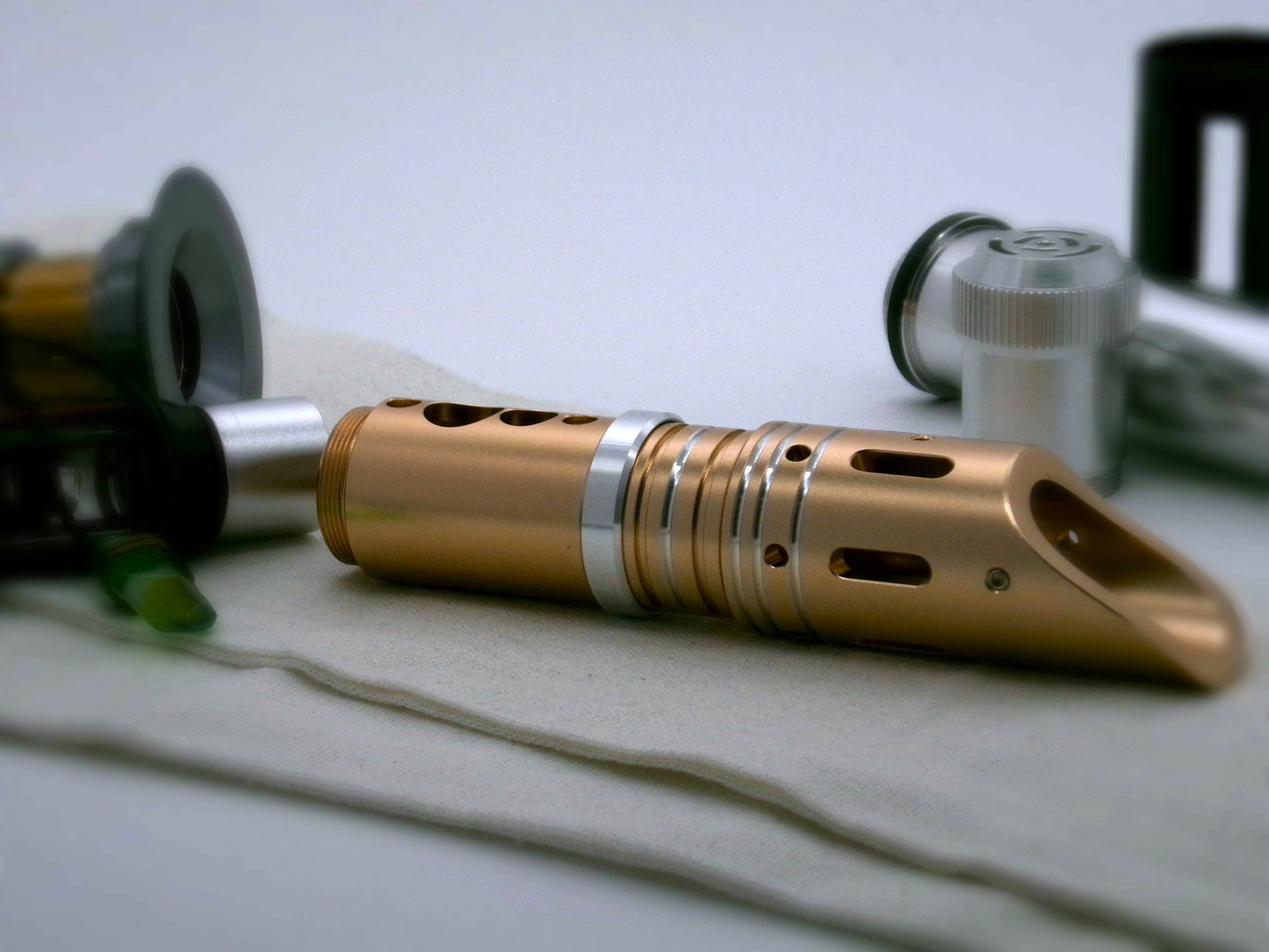 Single, aluminum accent ring with beveled edges installed on a golden lightsaber between the switch and emitter of a VHC lightsaber.