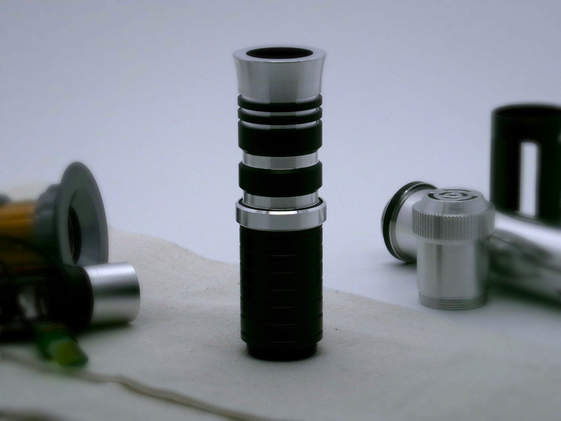 Single, aluminum accent ring with beveled edges installed between a mixed finish emitter and black extension of a VHC lightsaber.