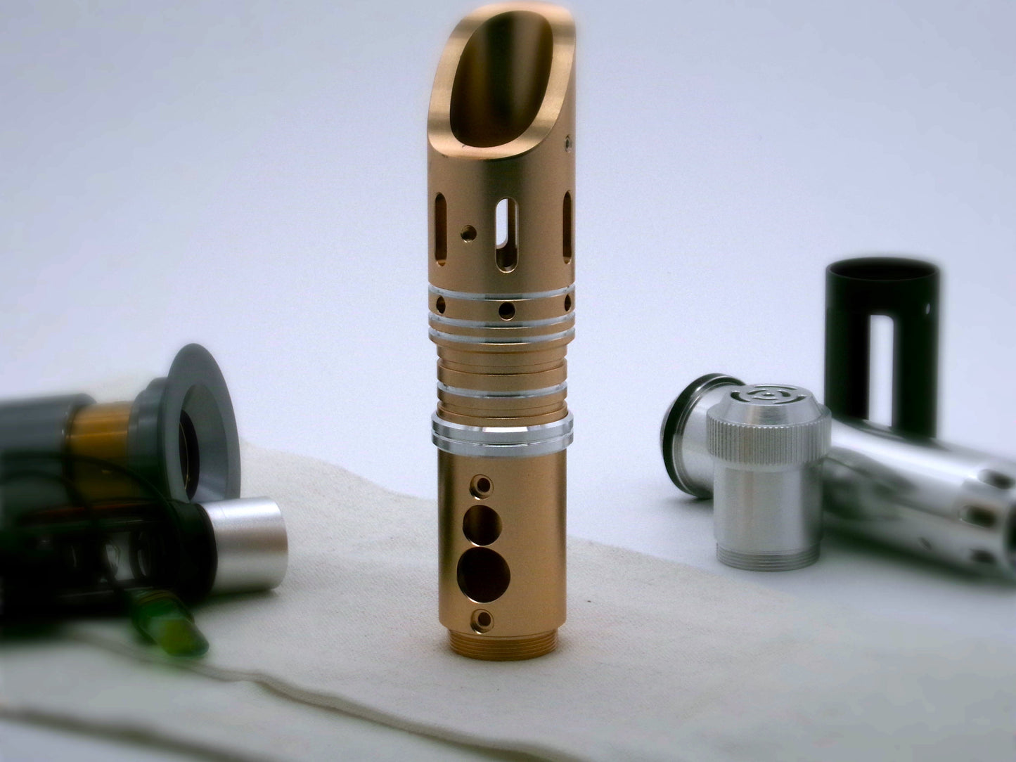 Single, aluminum accent ring with beveled edges and a central groove installed between the switch and emitter of a golden bodied VHC lightsaber.