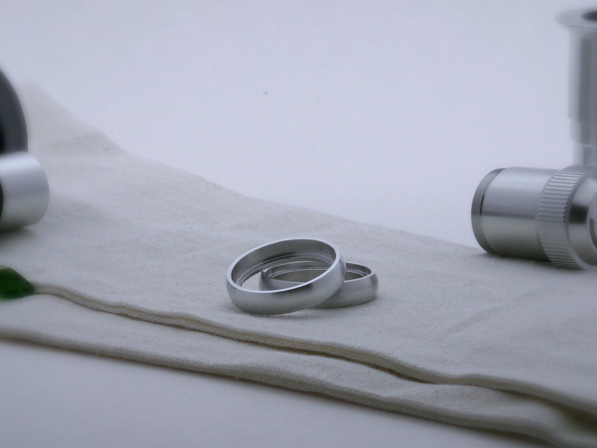 Pair of rounded profile aluminum accent rings for VHC lightsabers, one askew upon the other, showing shimsert.