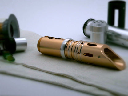Single, rounded profile, aluminum accent ring installed between the switch and emitter of a golden VHC lightsaber.