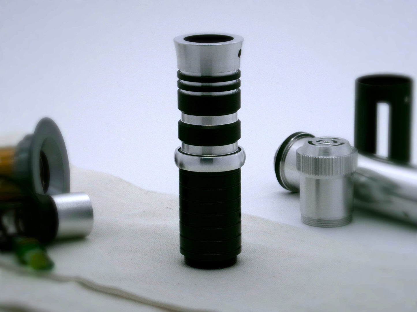 A single, rounded profile aluminum accent ring installed between a mixed finish emitter and black extension of a VHC lightsaber.