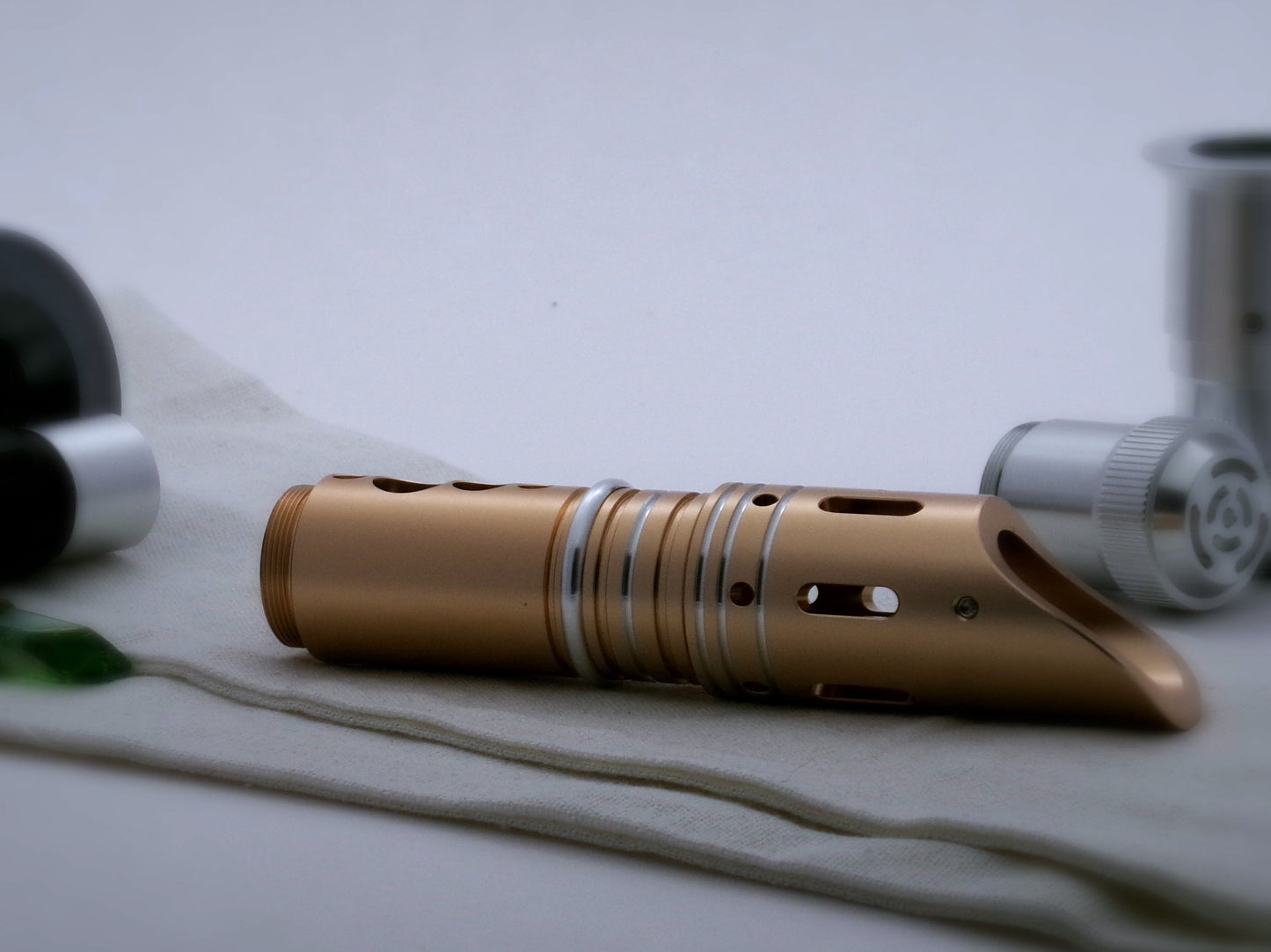 Single, round profile aluminum accent ring installed between the switch and emitter of a golden VHC lightsaber.