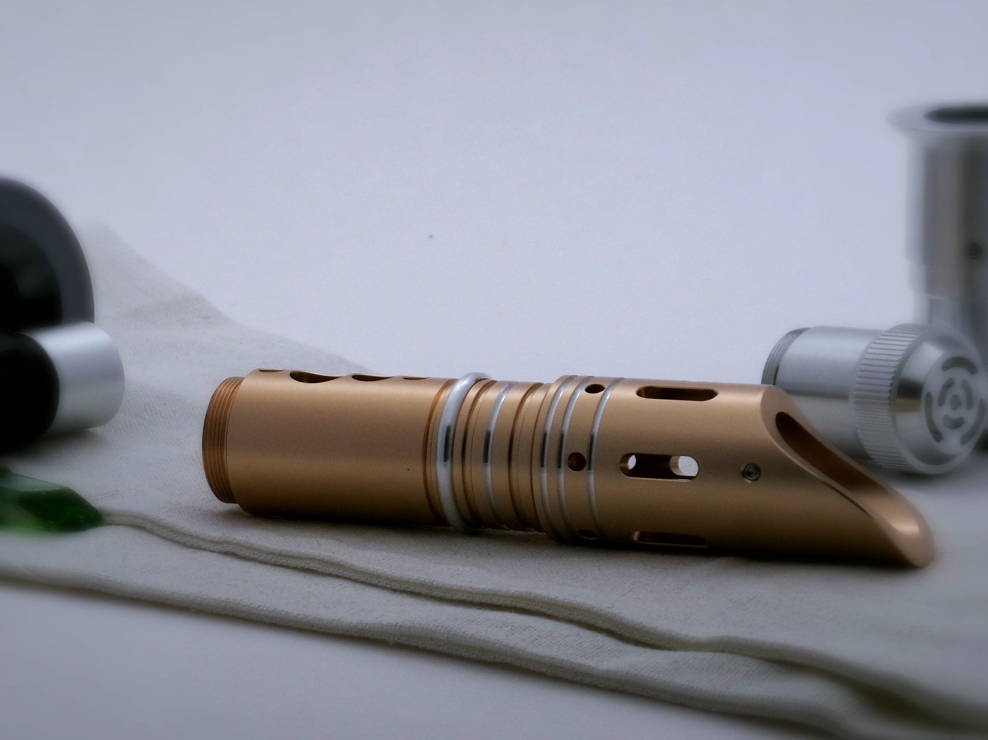 Single, round profile aluminum accent ring installed between the switch and emitter of a golden VHC lightsaber.