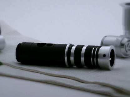 A single, round profile aluminum accent ring installed between a mixed finish emitter and black extension of a VHC lightsaber.
