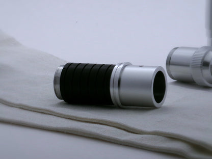 Single, aluminum accent ring with offset bands and a deep central groove installed on mixed components of a VHC lightsaber.