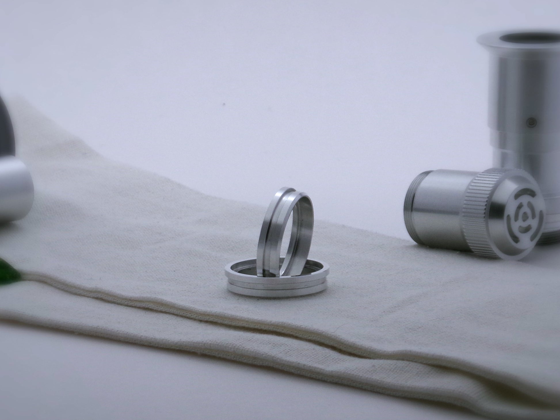 Pair of simple accent rings for VHC lightsabers with offset bands and deep central groove, one standing vertically on edge inside the other.