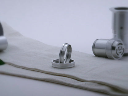 Pair of simple accent rings for VHC lightsabers with offset bands and deep central groove, one standing vertically on edge inside the other.