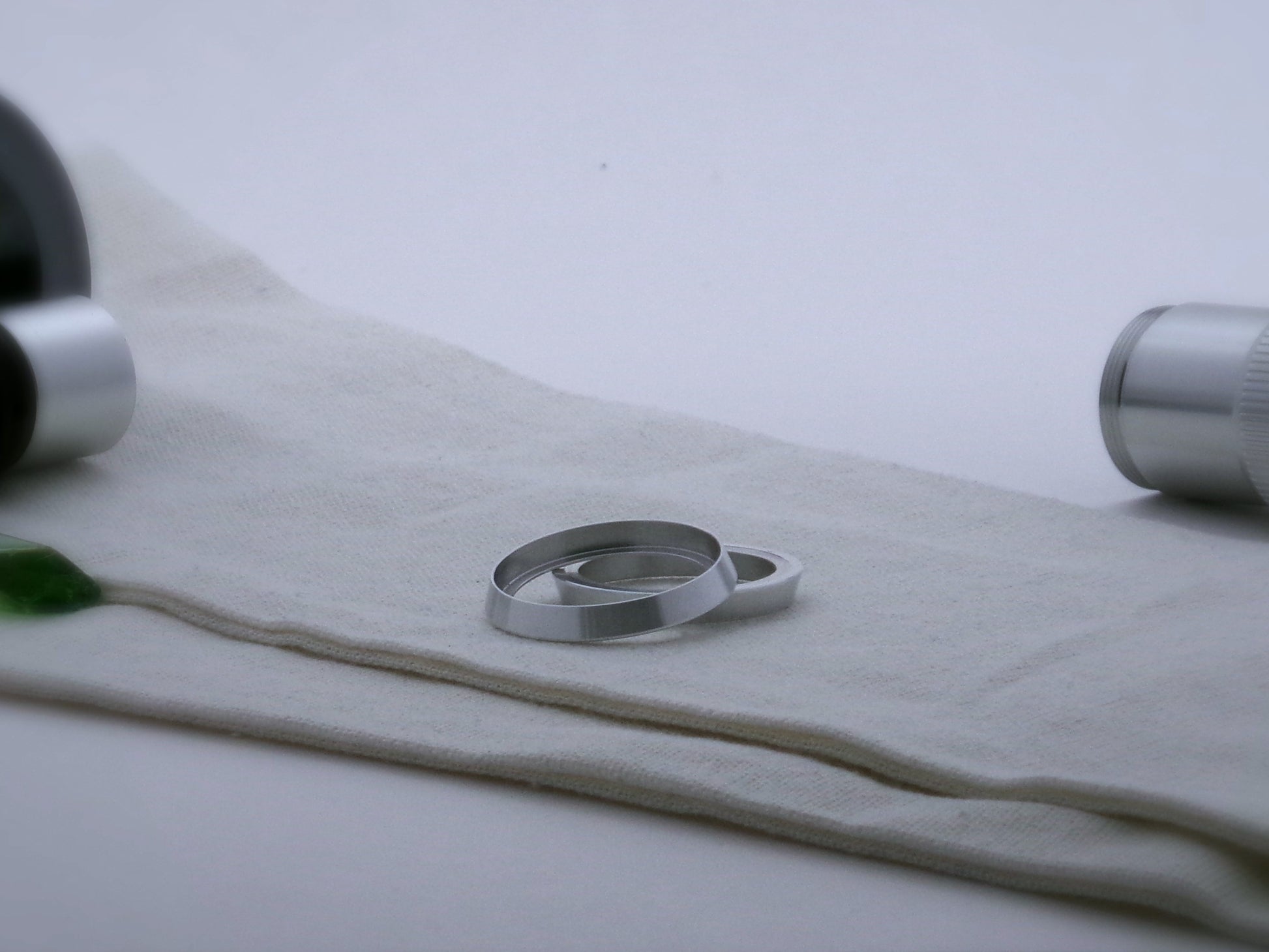 Pair of bevelled aluminum accent rings for VHC lightsabers, one askew upon the other, showing shimsert.