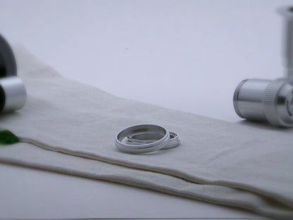 Pair of aluminum accent rings for VHC lightsabers with a proud central rib, one askew upon the other, showing shimsert.