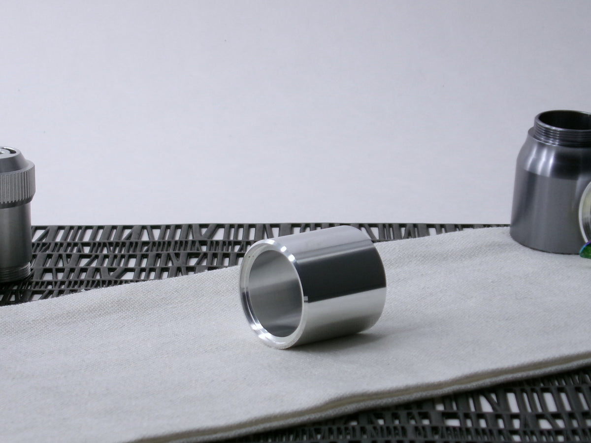 A beveled, VHC-compatible, lightsaber Accent Sleeve sits 3/4 view showing shim-sert, on a cloth.