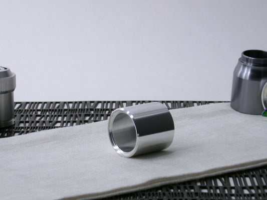 A beveled, VHC-compatible, lightsaber Accent Sleeve sits 3/4 view showing shim-sert, on a cloth.