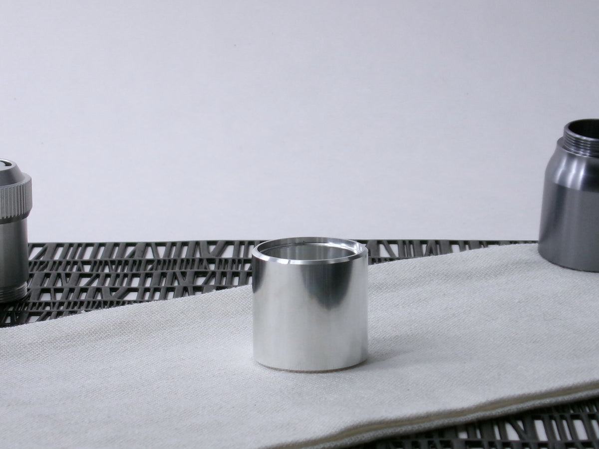 A beveled, VHC-compatible lightsaber Accent Sleeve sits vertical on a cloth.