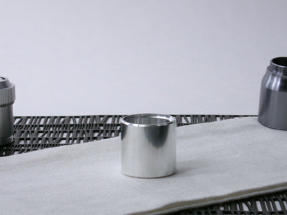 A beveled, VHC-compatible lightsaber Accent Sleeve sits vertical on a cloth.