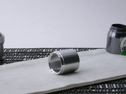 A stepped, VHC-compatible, lightsaber Accent Sleeve sits 3/4 view showing shim-sert, on a cloth.