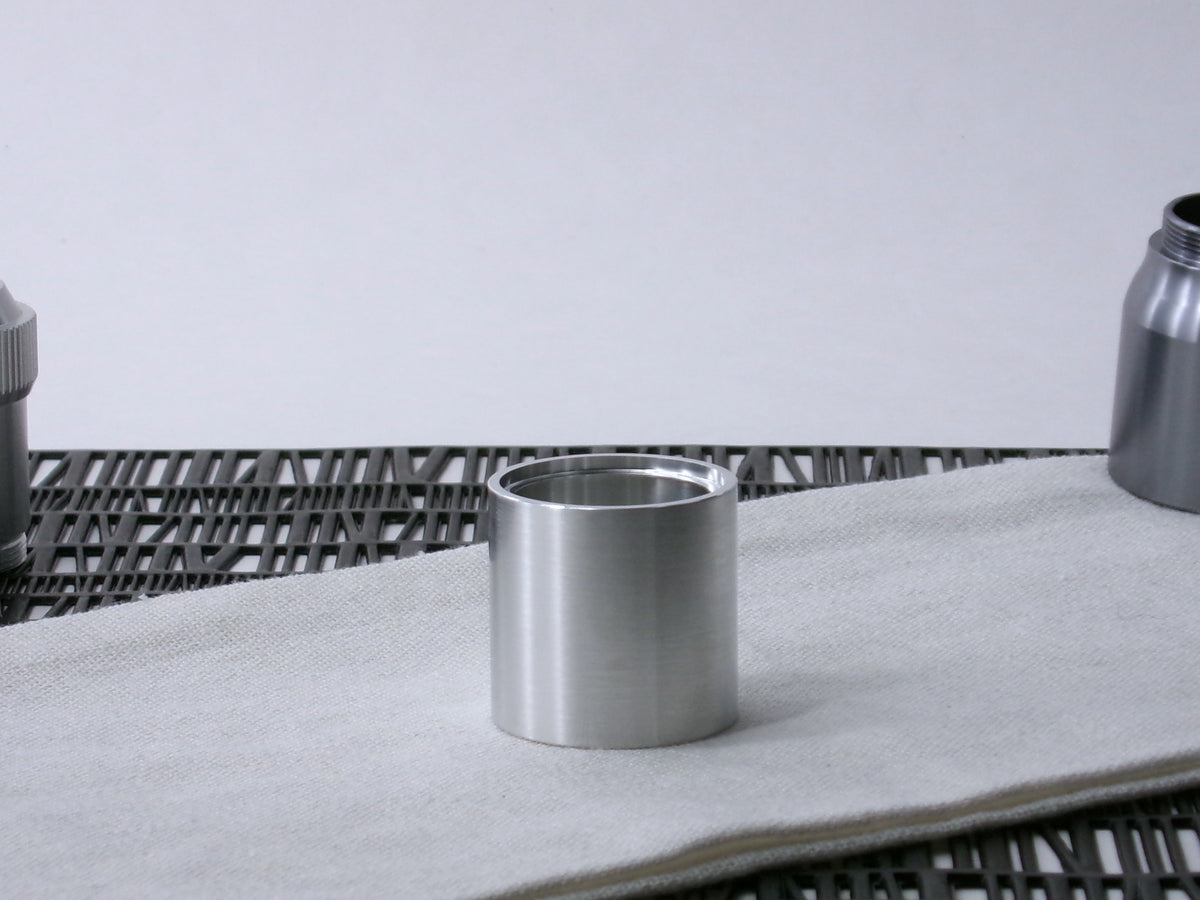 A plain, VHC-compatible, lightsaber Accent Sleeve sits vertical on a cloth.