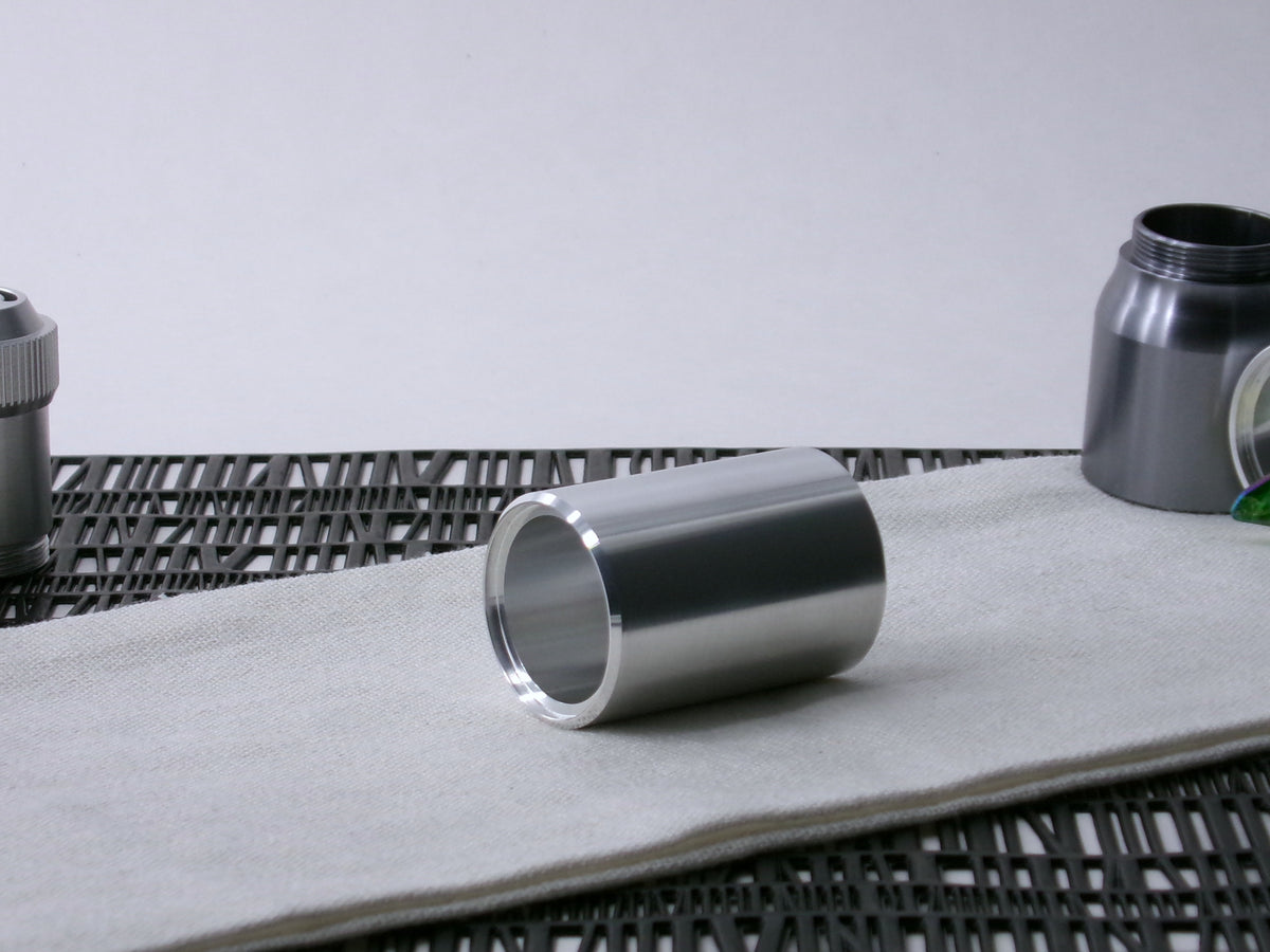 A beveled, VHC-compatible, lightsaber Accent Sleeve sits 3/4 view showing shim-sert, on a cloth.