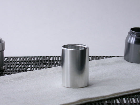 A beveled, VHC-compatible, lightsaber Accent Sleeve sits vertical on a cloth.